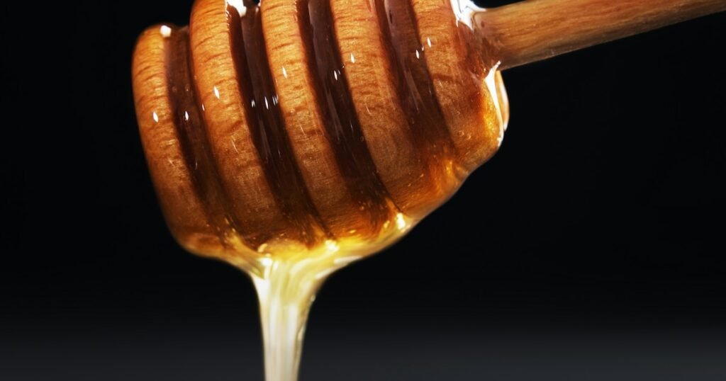 ملعقة عسل مانوكا يقطر منها العسل